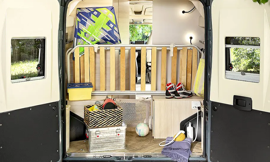 Der Heckbereich des Chausson F&S (2025) mit hochgeklappten Etagenbetten bei geöffneten Hecktüren.
