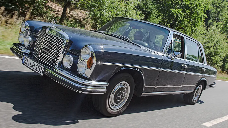 Mercedes 300 SEL 3.5 fährt auf einer Landstraße, Ansicht von vorne links.