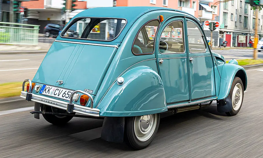 Die Citroën 2CV fahrend von schräg hinten fotografiert.