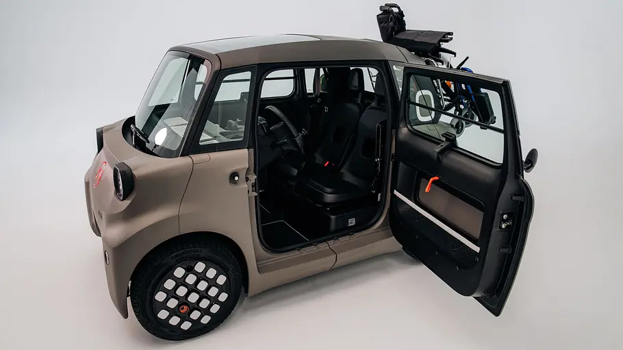 Citroën Ami for all Citroën Ami for all mit weit geöffneter Fahrertür und Rollstuhl auf dem Heckträger.