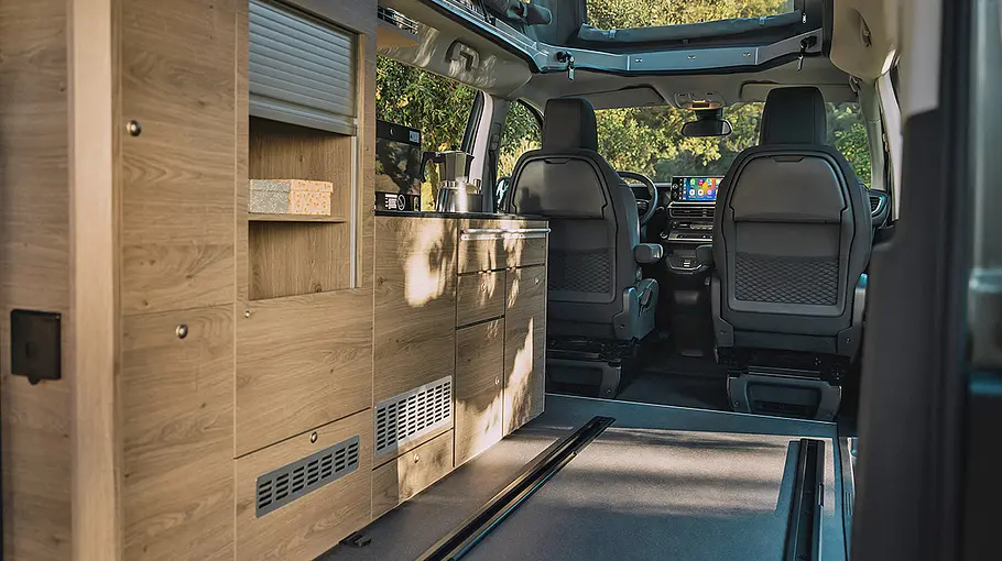 Durchsicht von hinten durch den Kofferraum nach vorne durch den Wohnraum des Citroën Holidays mit Blick auf Küchen- und Schrankzeile.