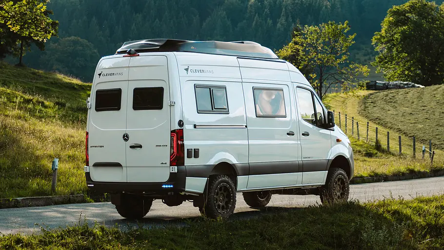 Der Clever Vans Aventuro 600 statisch von schräg hinten rechts auf einem Waldweg.