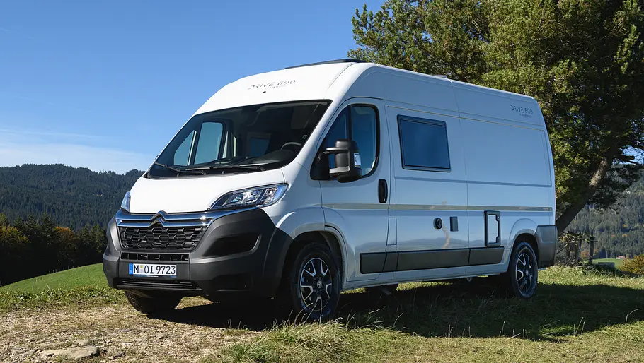 Der Clever Vans Drive 600 statisch von schräg vorne links auf einer Wiese vor einem Waldstück.