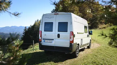 Der Clever Vans Drive 600 statisch von schräg hinten rechts auf einer Wiese vor einem Waldstück. - Foto: Clever Vans