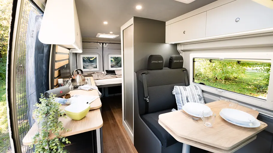 Durchsicht durch den Wohnraum des Clever Vans Drive 600 mit Blick aus dem Cockpit in Richtung Heck.