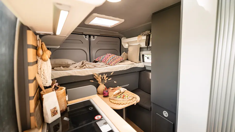 Clever Vans Duo 540 Durchsicht durch den Wohnraum des Clever Vans Duo 540 im Tagumbau mit Sitzgruppe am Bett.