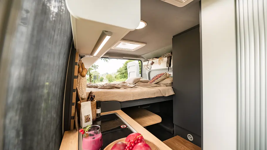 Clever Vans Duo 540 Durchsicht durch den Wohnraum des Clever Vans Duo 540 im Nachtumbau mit Doppelbett in voller Breite. Die Hecktüren sind geöffnet.