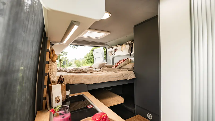 Clever Vans Duo 540 Durchsicht durch den Wohnraum des Clever Vans Duo 540 im Nachtumbau mit Doppelbett in voller Breite. Die Hecktüren sind geöffnet.