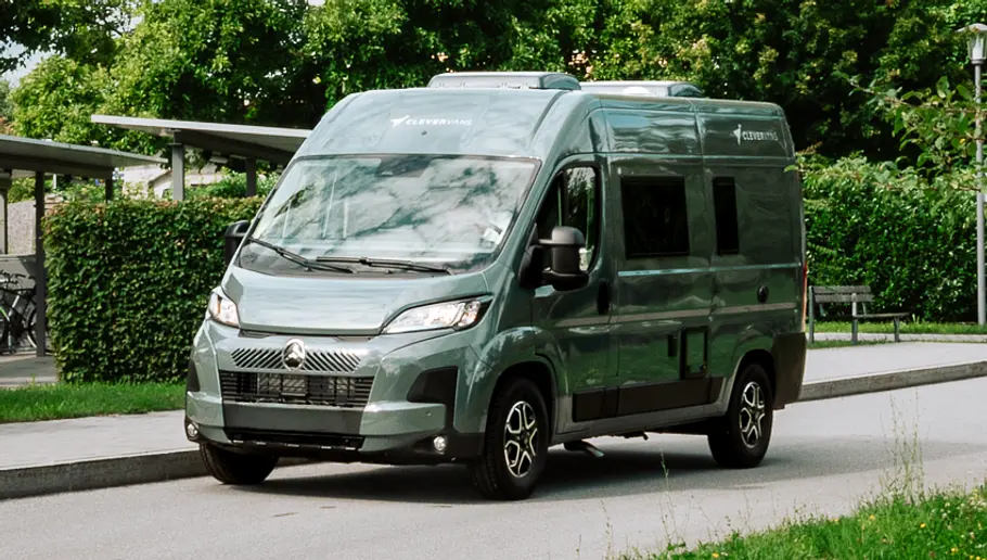 Clever Vans Tour 540 Der Clever Vans Tour 540 statisch von schräg vorne links neben einer Bushaltestelle.