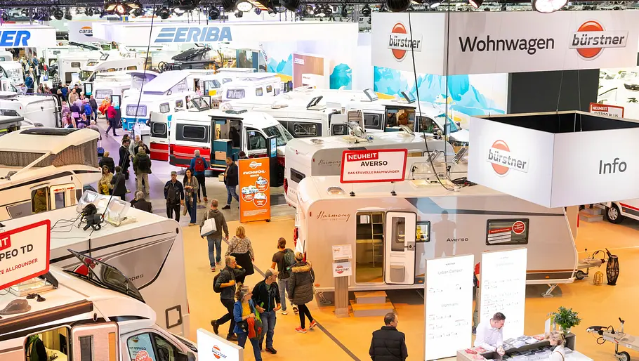 Blick aus leicht erhöhter Position über eine Halle der Messe Stuttgart, in der während der CMT 2025 Campingfahrzeuge verschiedener Hersteller gezeigt werden.
