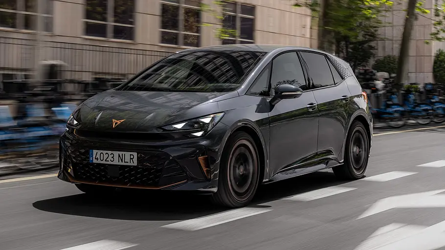 Cupra Born Facelift 2026 Die fahrdynamische Aufnahme zeigt den Cupra Born (2026) vor einer urbanen Kulisse von schräg seitlich.