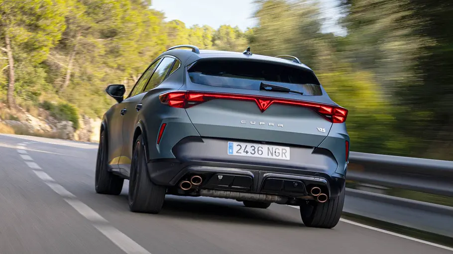 Der Cupra Formentor VZ5 fährt auf einer Landstraße, von hinten links fotografiert.
