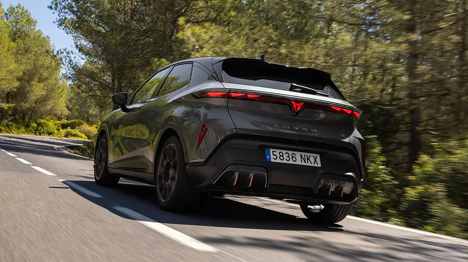 Der Cupra Raval VZ fährt auf einer Landstraße, von hinten fotografiert.