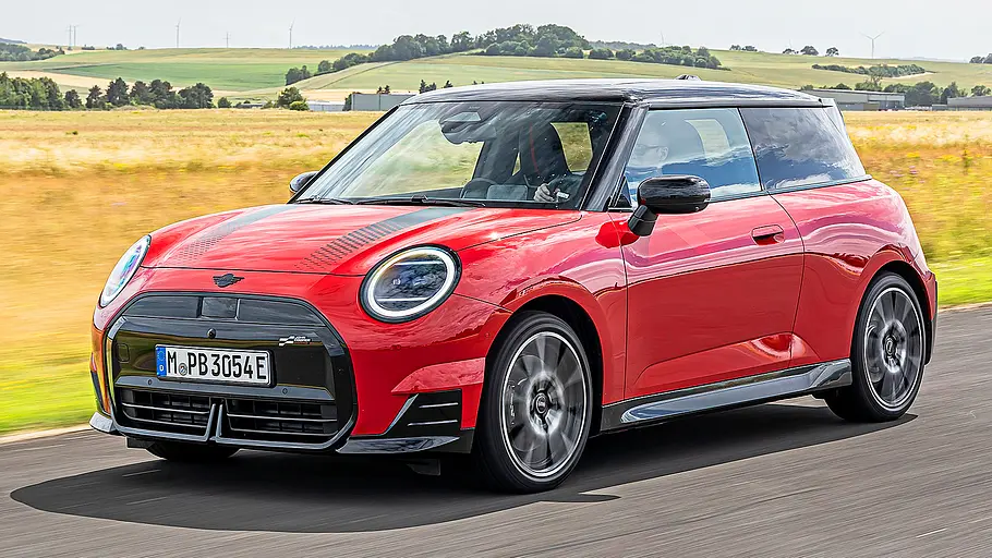 Blick von schräg vorne auf den fahrenden Mini Cooper SE.