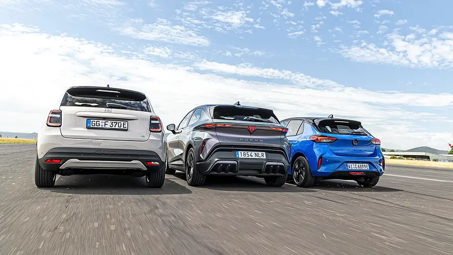 Cupra Raval Endurance, Opel Corsa-e und Fiat 600e fahren nebeneinander über eine Asphaltpiste, Ansicht von hinten