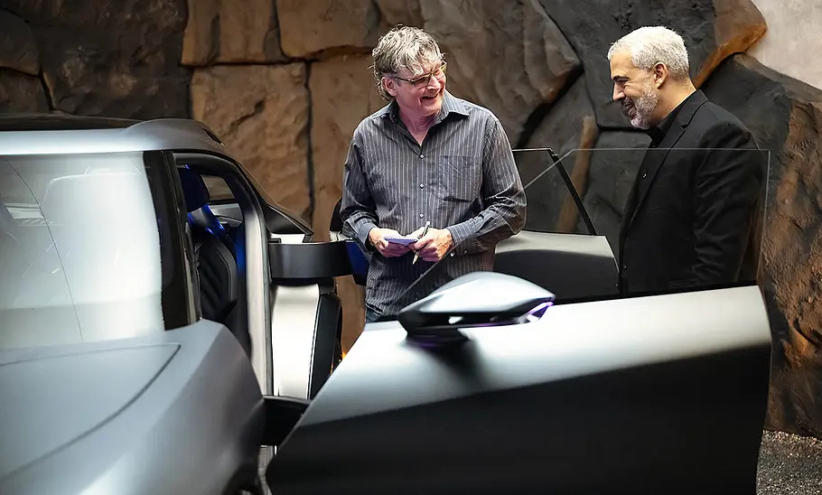 Ein Redakteur der AUTO ZEITUNG steht mit dem Cupra-Designchef Jorge Díez seitlich vor der geöffneten Fahrertüre der IAA-Konzeptstudie Cupra Tindaya (2025).