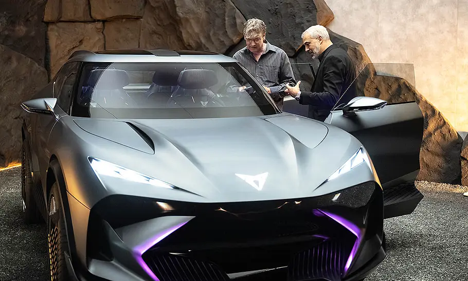 Ein Redakteur der AUTO ZEITUNG steht mit dem Cupra-Designchef Jorge Díez seitlich vor der geöffneten Fahrertüre der IAA-Konzeptstudie Cupra Tindaya (2025).
