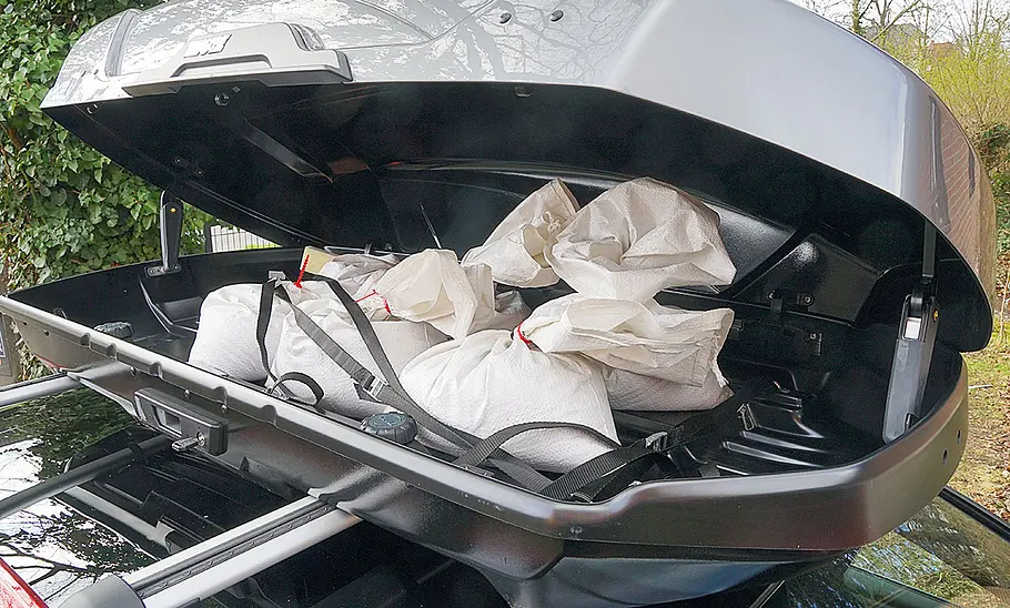 Das Bild zeigt die für den Test mit 50 kg Sandsäcken beladene, geöffnete Dachbox im Detail.