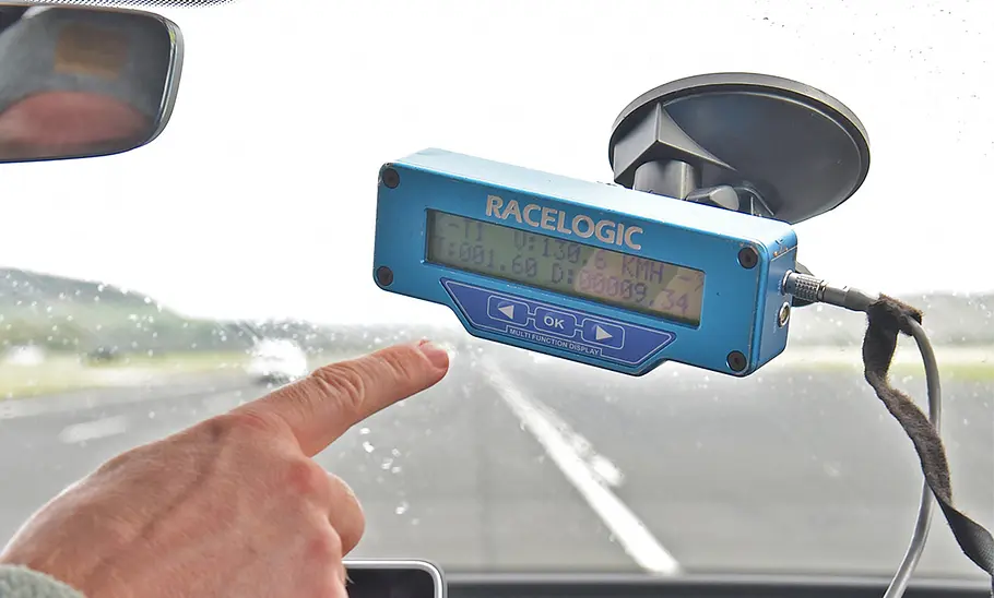 Dachboxen-Test Ein Testfahrer zeigt mit dem Finger auf die Anzeige mit den Telemetriedaten.