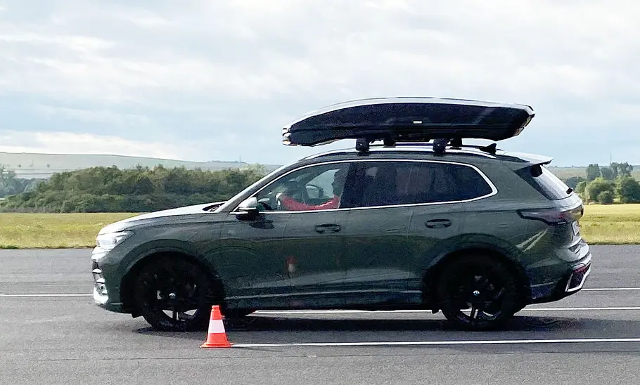 Thule Vector L im Dachboxen-Test Dachbox Thule Vector L beim Fahrdynamik-Test auf einem VW Tiguan, fotografiert von der Seite.