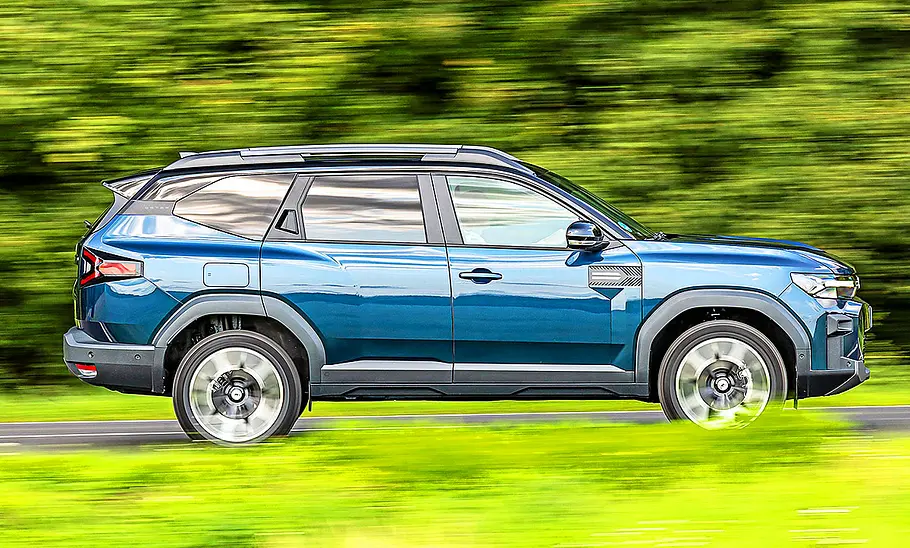 Dacia Bigster Blick von der Seite auf den fahrenden Dacia Bigster.