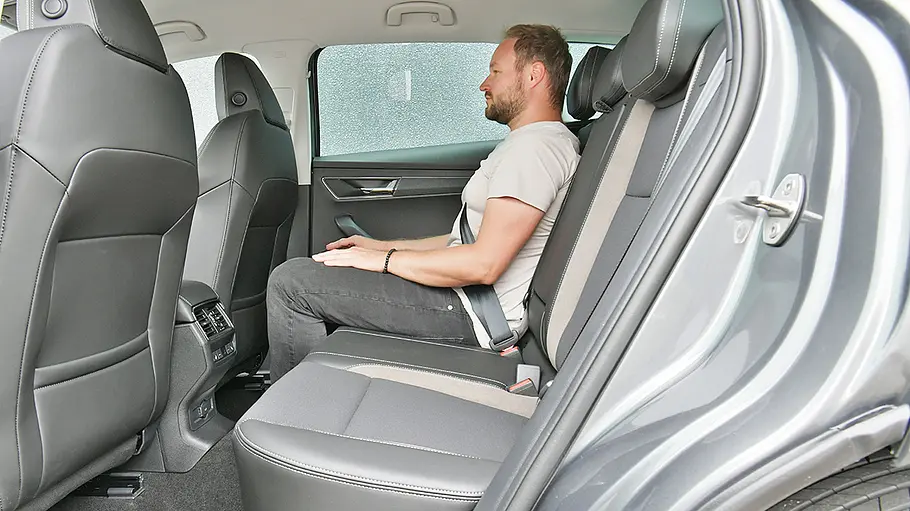 Ein Mann sitzt im Fond des Skoda Karoq.