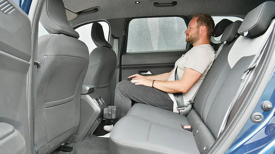 Ein Mann sitzt im Fond des Dacia Bigster.