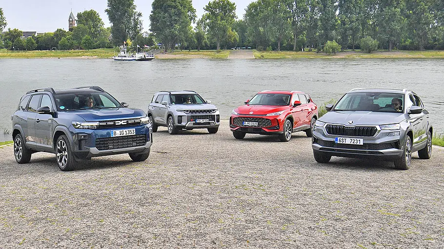 Dacia Bigster, KGM Torres, MG HS und Skoda Karoq stehen in einer Formation an einem Pier, von vorne fotografiert.