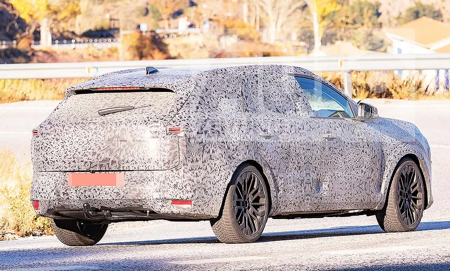 Blick von schräg hinten auf den fahrenden Dacia C-Neo Kombi (2026).