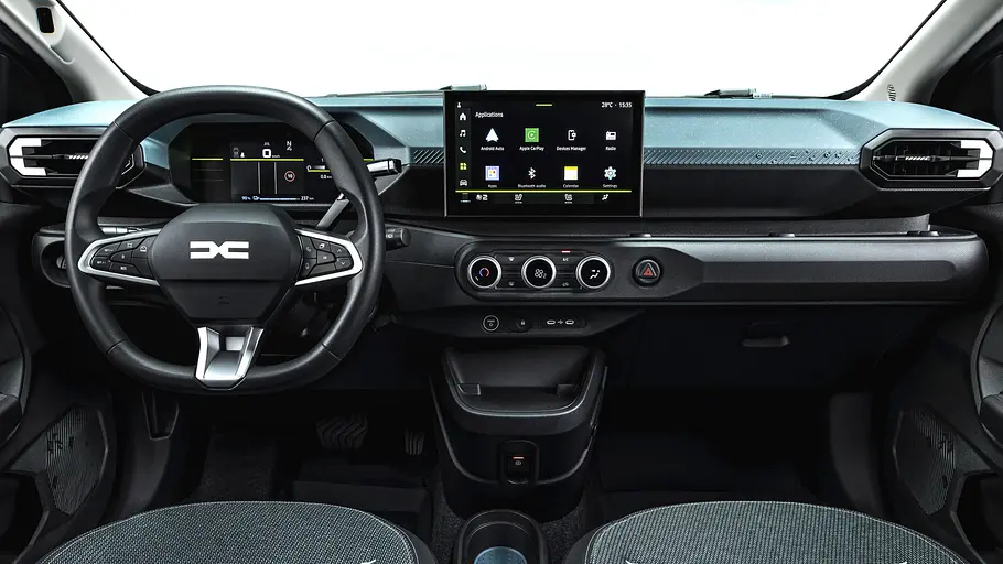 Das Cockpit eines Dacia Spring zeigt ein Lenkrad, digitale Instrumente, einen zentralen Bildschirm und drei runde Klimaregler.