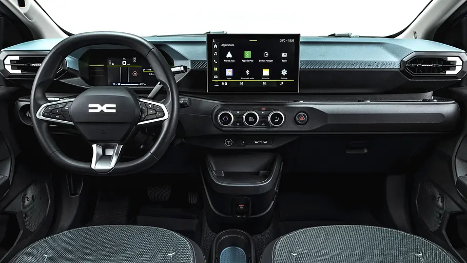 Das Cockpit eines Dacia Spring zeigt ein Lenkrad, digitale Instrumente, einen zentralen Bildschirm und drei runde Klimaregler.