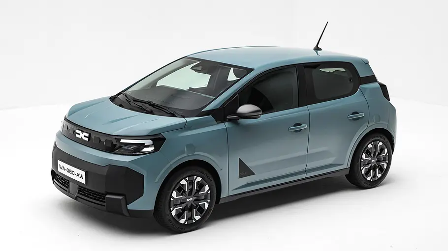Ein hellblauer Dacia Spring mit schwarzen Zierelementen steht schräg von vorn gesehen vor weißem Hintergrund.
