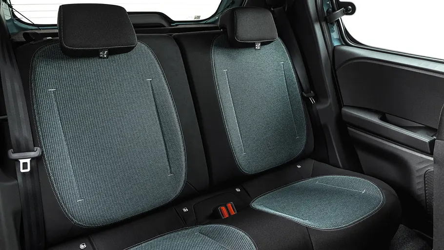 Die Rückbank des Dacia Spring hat zwei Sitzplätze mit schwarz-türkisen Stoffbezügen, Kopfstützen und Sicherheitsgurten.