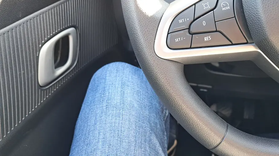 Dacia Spring (2026) Die Innenaufnahme zeigt den Oberschenkel eines Testers, der auf dem Fahrersitz sitzt.