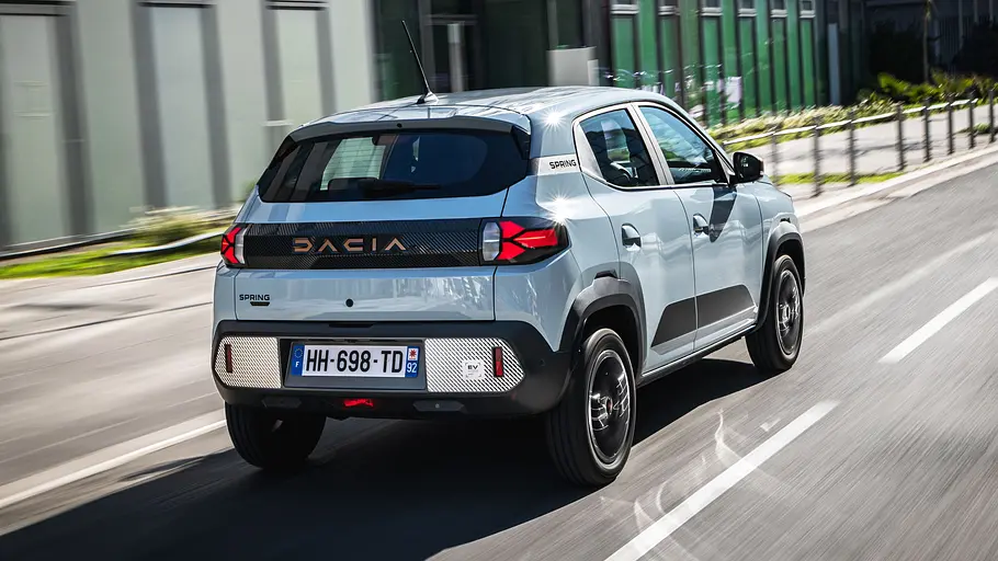 Dacia Spring (2026) Die fahrdyanmische Aufnahme zeigt den Dacia Spring (2026) von schräg hinten.