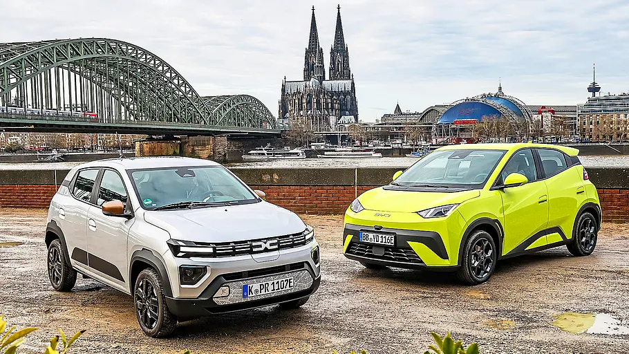 Dacia Spring/BYD Dolphin Surf Blick von schräg vorne auf die E-Kleinstwagen Dacia Spring und BYD Dolphin Surf.