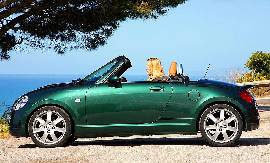 Der Daihatsu Copen fahrend mit offenem Verdeck.