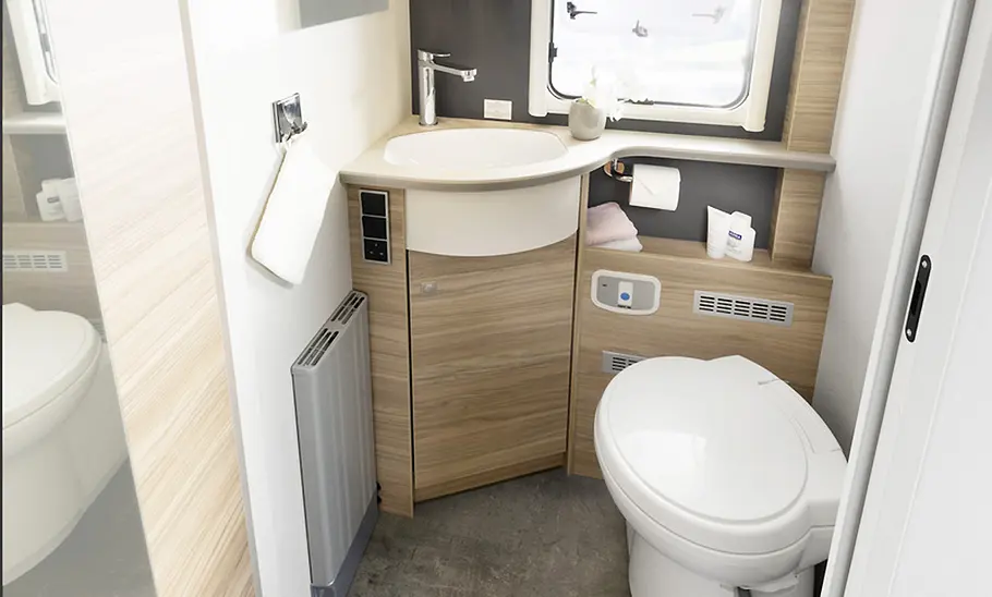 Ein Blick ins Badezimmer des Dethleffs Alpa Alkoven (2025) mit WC und Waschbecken.