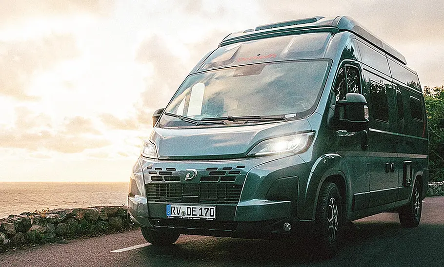 Der Dethleffs Globetrail 540 DR (2025) von schräg vorne auf einer Küstenstraße.
