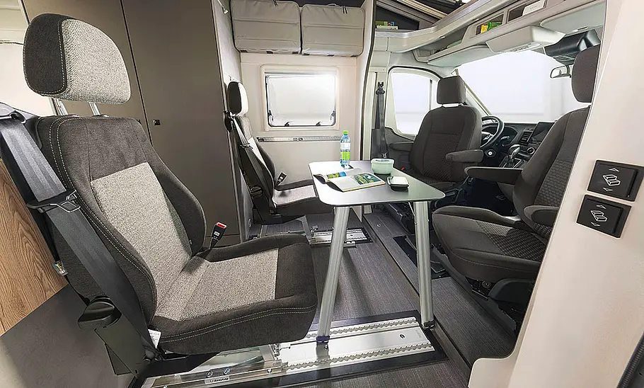 Dethleffs Yoka Go T1 (2024) Das Bild zeigt den Wohnraum des Dethleffs Yoka Go T1 (2024) mit Tisch und viertem Sitzplatz.