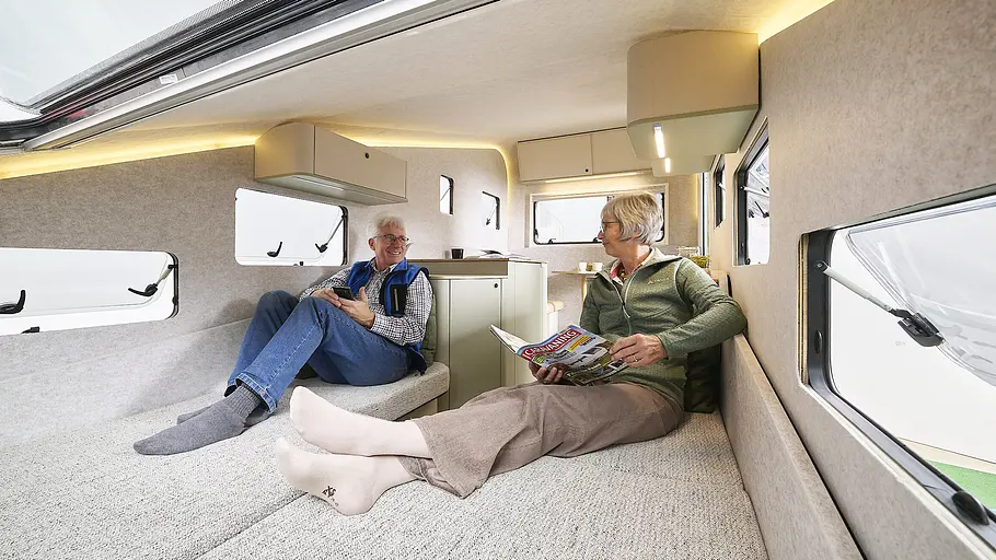Ein Ehepaar liegt im Schlafzimmer der Dethleffs-Studie c.fold (2026) auf Einzelbetten. 