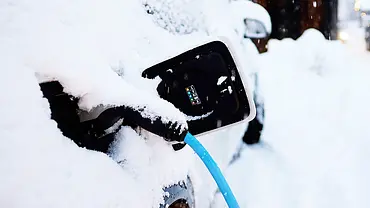 Ein Fahrzeug ist schneebedeckt, der Stecker steckt in der Ladebuchse. - Foto: Imago Ein Fahrzeug ist schneebedeckt, der Stecker steckt in der Ladebuchse. - Foto: Imago