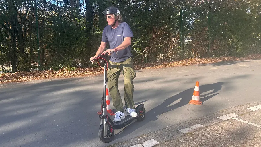 E-Scooter Segway Ninebot F3 Pro D Die Außenaufnahme zeigt einen Testredakteur auf dem E-Scooter Segway Ninebot F3 Pro D beim Durchfahren eines Hütchen-Pacours.