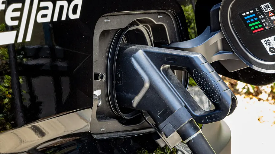 Der Ladeanschluss des Eifelland Nissan Interstar-e mit einem eingesteckten Ladekabel im Detail.