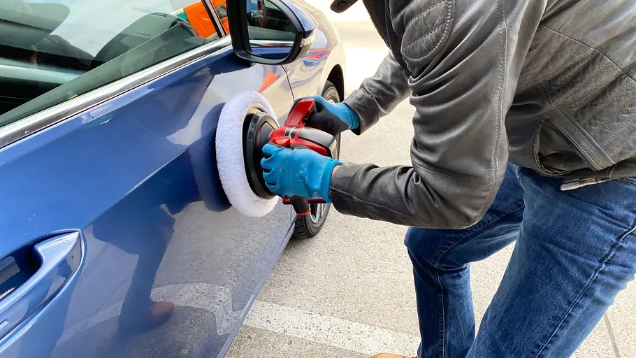 Einhell-Akku-Poliermaschine im Test. Ein Tester poliert die vordere, rechte Autotür.