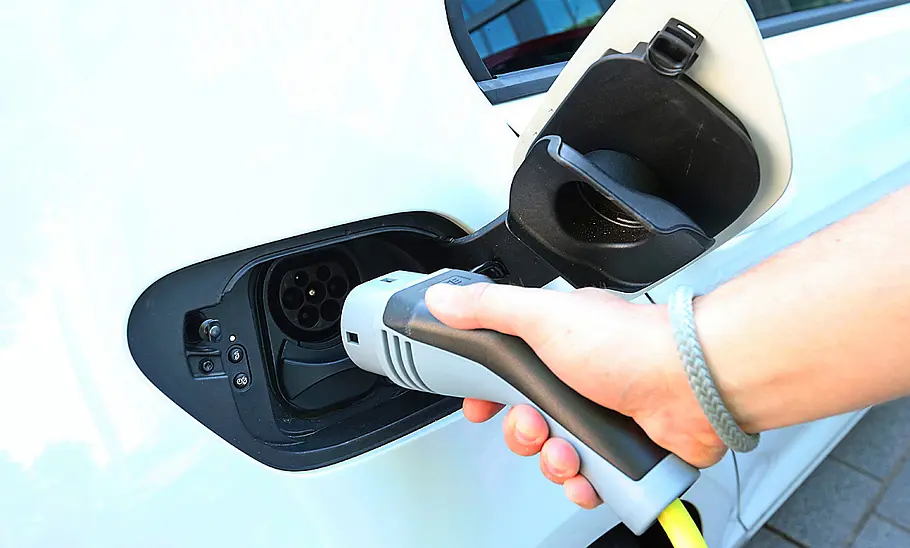 E-Autos mit großer Reichweite Detailaufnahme von Ladestecker, der in E-Auto gesteckt wird.