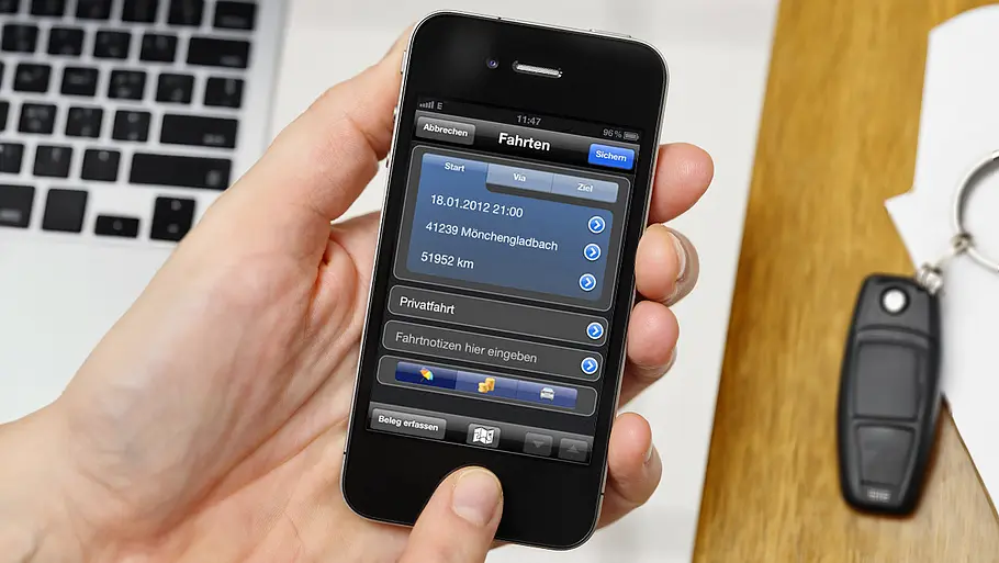 Eine Hand hält ein Smartphone mit geöffneter Fahrtenbuch-App.