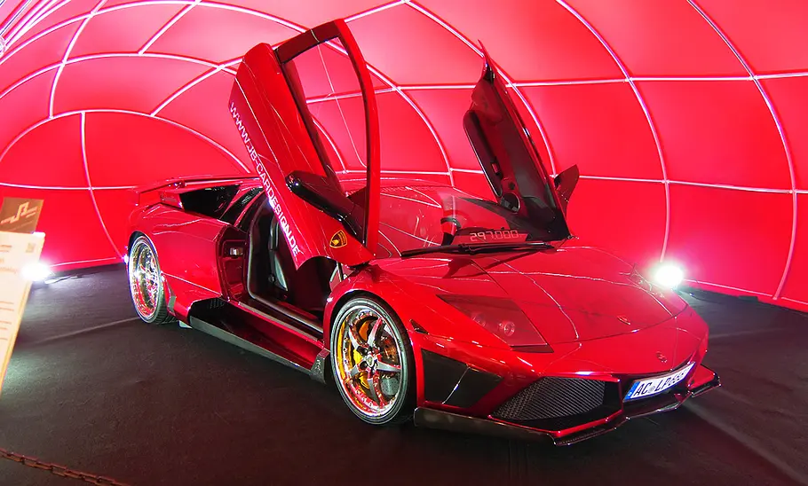 Lamborghini Murcièlago in Rotchrom mit geöffneten Flügeltüren auf der Essen Motor Show 2024 von schräg vorne fotografiert.