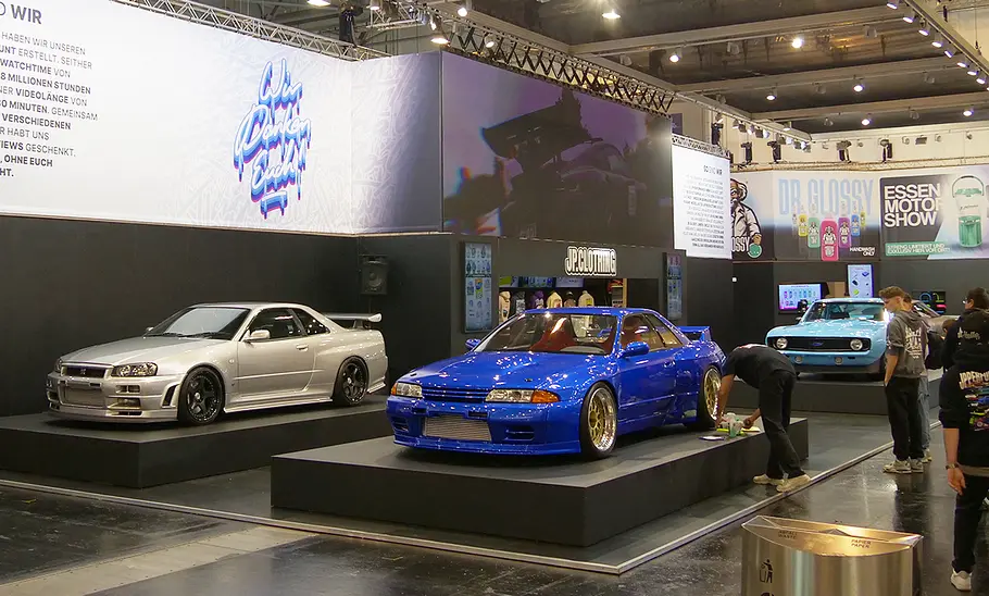 JP Performance auf der Essen Motor Show 2025 Der Stand von JP Performance auf der Essen Motor Show, man sieht mehrere Fahrzeuge auf einem Podest stehen.