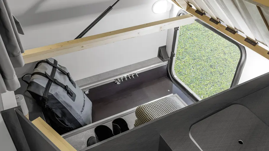 Blick in die Heckgarage des Etrusco T 5900 FB unter das hochgeklappte Heckbett.